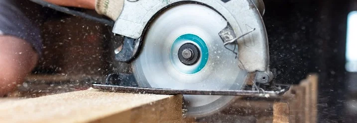 Person sägt Holz mit Handkreissäge